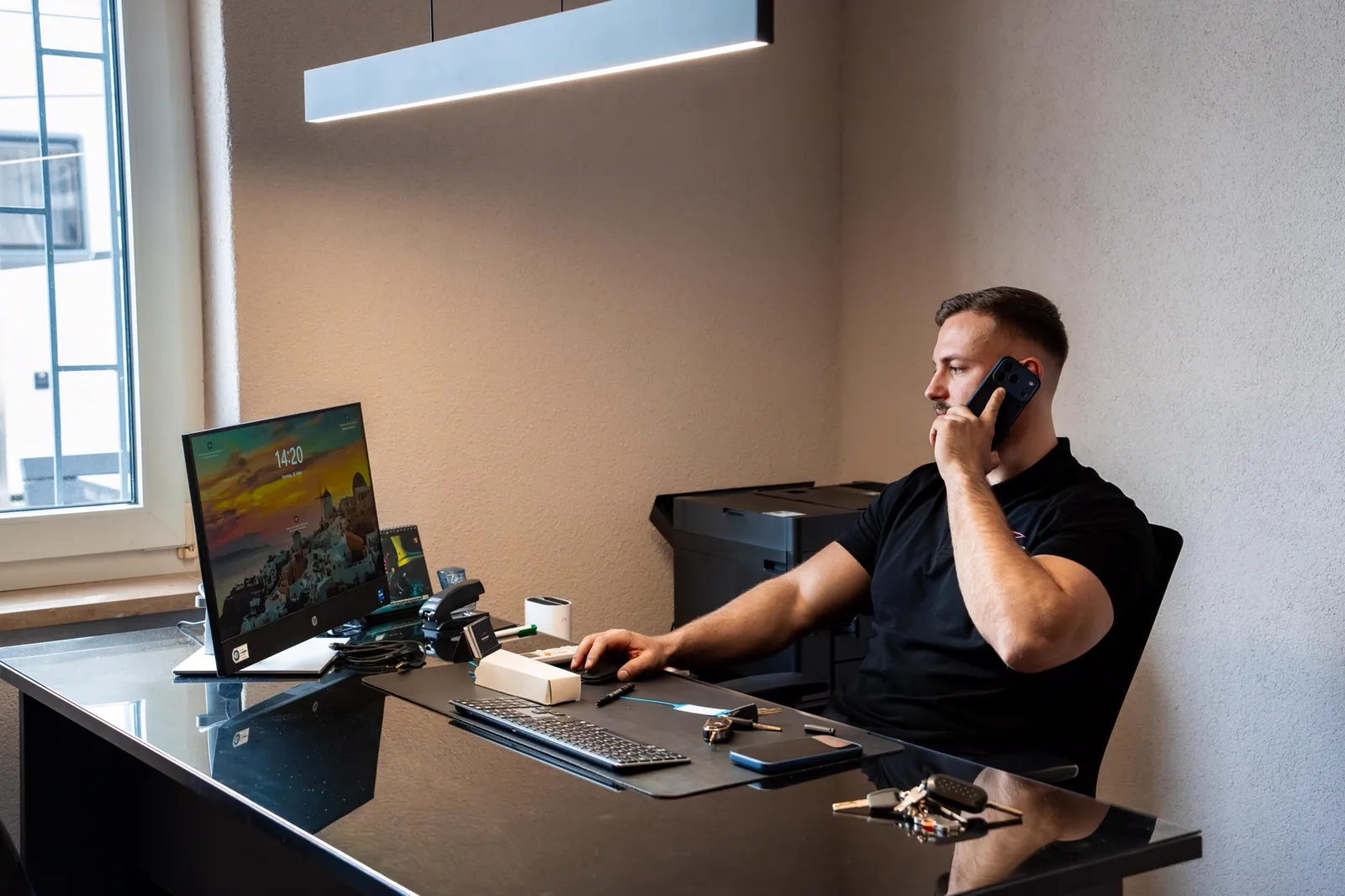 Kfz-Sachverständiger Daniel Rudi nimmt am Schreibtisch telefonisch eine Schadenmeldung auf