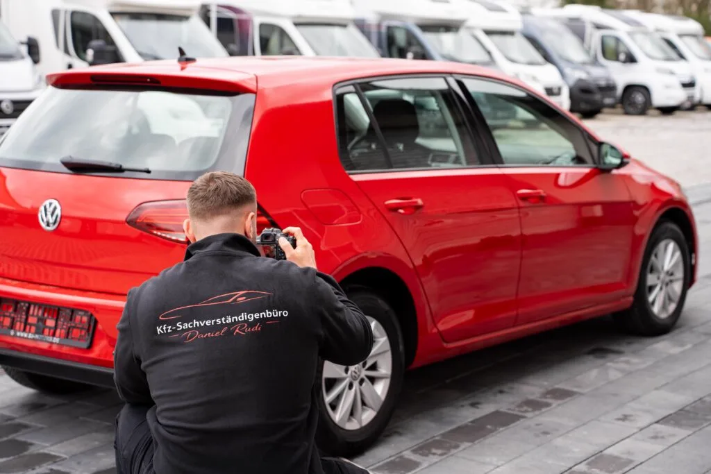 Kfz-Sachverständiger Daniel Rudi fotografiert das Heck eines Fahrzeugs für die Wertermittlung